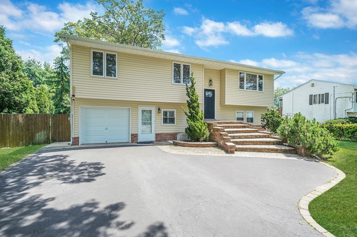 Bi-level home with driveway and a garage