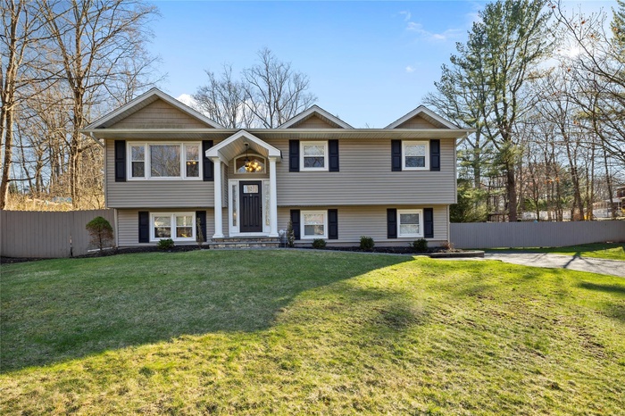 Bi-level home featuring fence and a front yard