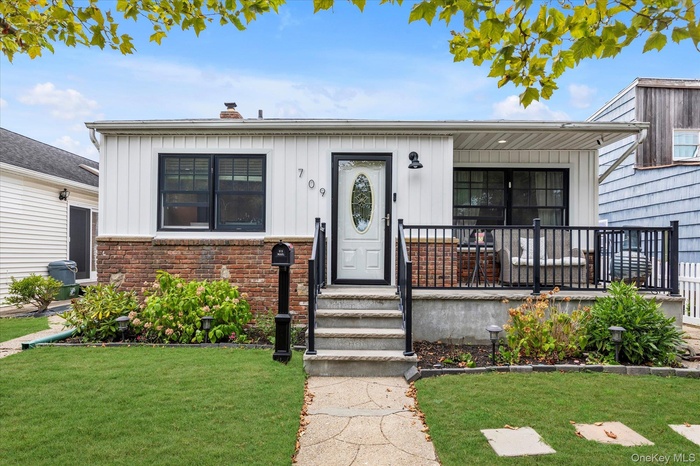 Bungalow featuring a chimney, board and batten siding, and a front yard