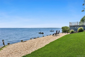 This stunning waterfront residence features over 100 feet of private beach and embodies the essence of coastal living.