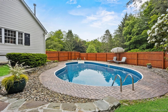 View of swimming pool featuring a fenced backyard and a patio