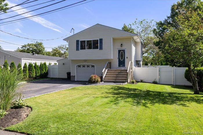 Bi-level home with a gate, driveway, and a garage