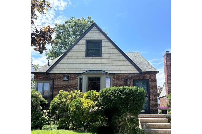 View of front of property featuring brick siding and a shingled roof