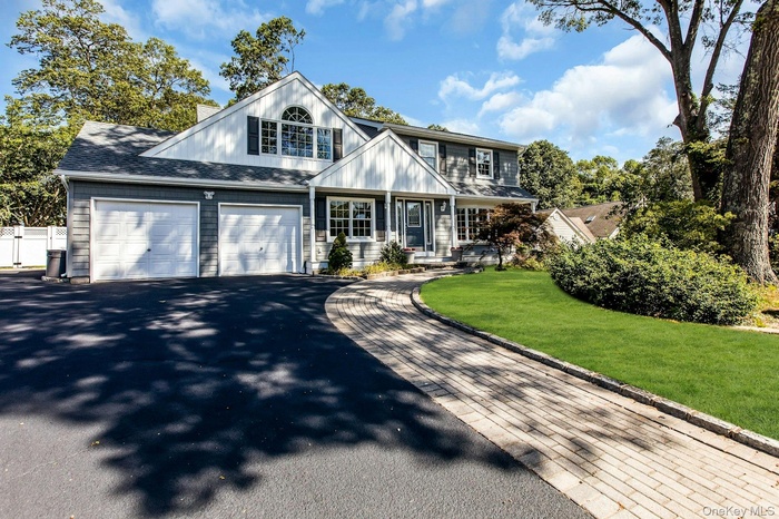 View of front of house featuring covered porch, driveway, a front lawn, board and batten siding, and an attached garage
