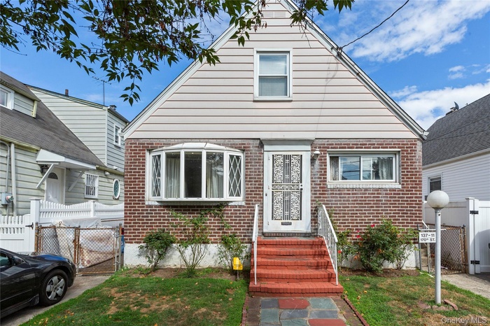 Bungalow-style home with brick siding and a gate