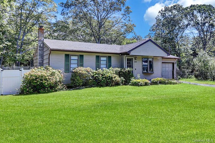 Ranch-style home with an attached garage and a chimney
