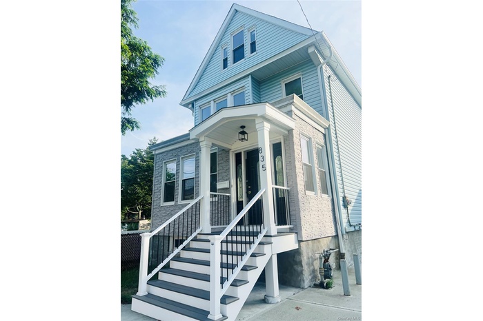 View of front of house with a porch and stone siding