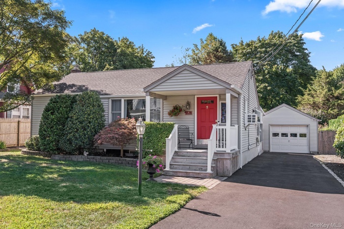 View of front of home featuring a detached 1.5 garage, a brand new roof brand new driveway, with covered porch