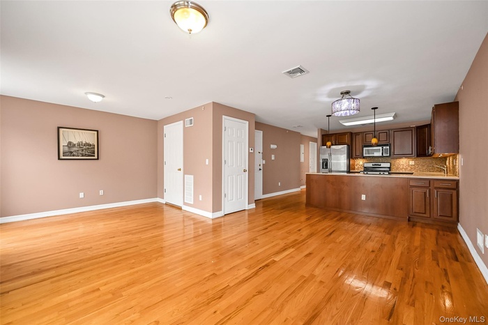 Unfurnished living room featuring baseboards and light wood-style floors