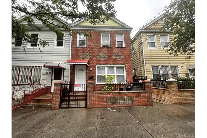 Traditional home featuring a gate, a fenced front yard, and brick siding
