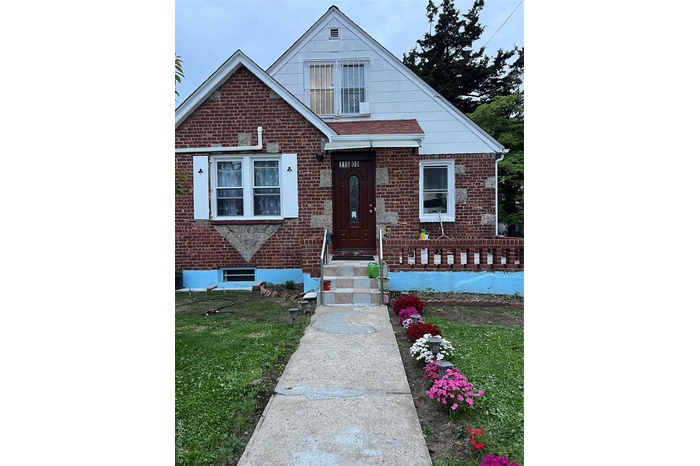 View of front of house with a front yard and brick siding