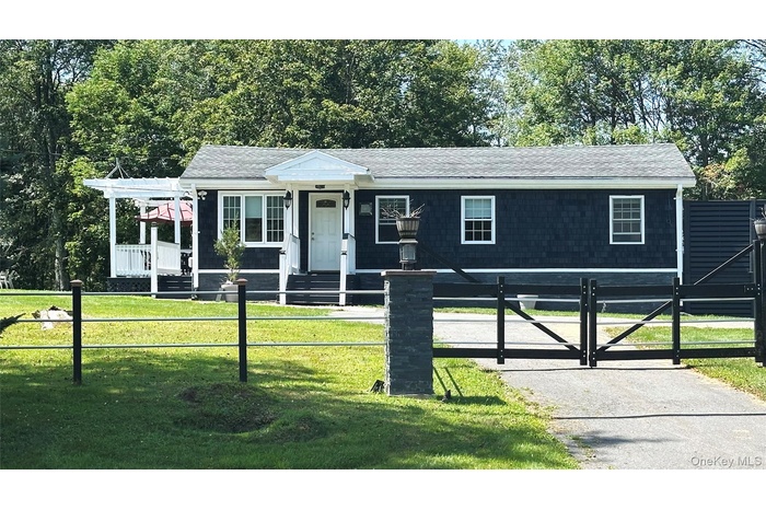 View of front of house featuring roof with shingles, a gate, and a fenced front yard