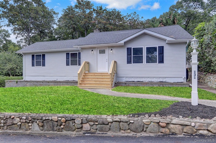 Ranch-style home with a chimney, roof with shingles, and a front lawn