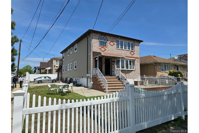 Traditional-style house with brick siding and a fenced front yard