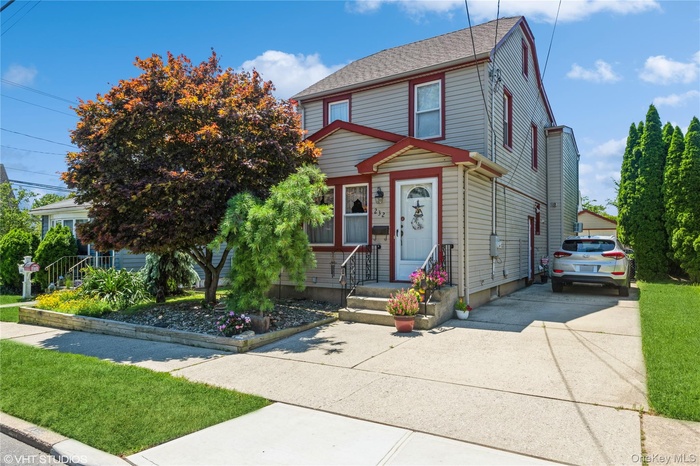 View of front of house featuring concrete driveway and a front yard