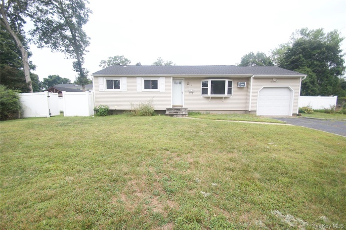 Ranch-style home featuring driveway, an attached garage, entry steps, and a gate