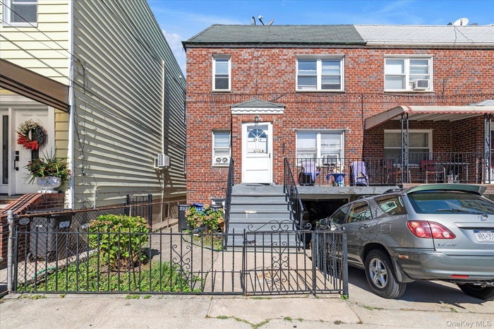 View of front facade with brick siding, a gate, and a fenced front yard