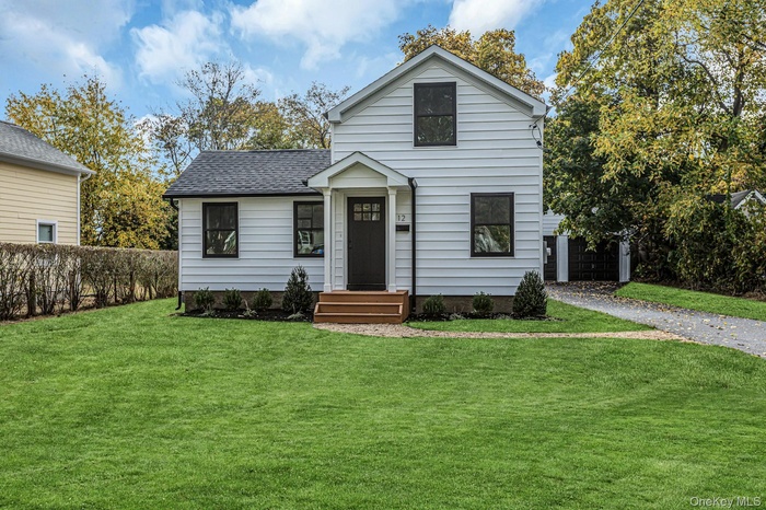 View of front of property with a shingled roof and driveway