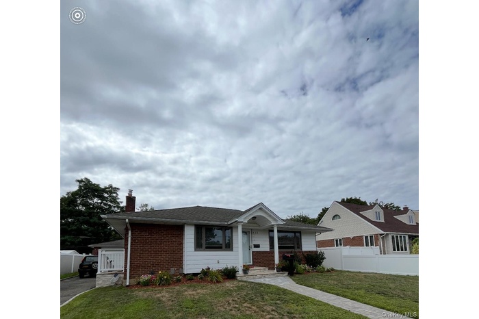 Ranch-style house with a chimney and brick siding