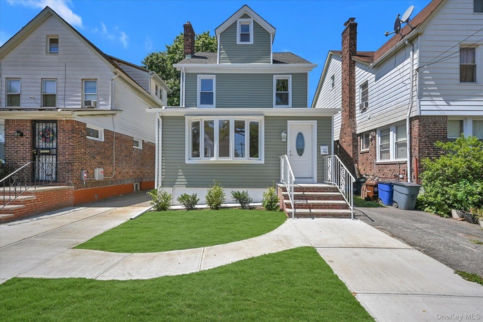 Traditional style home with a front lawn and roof with shingles