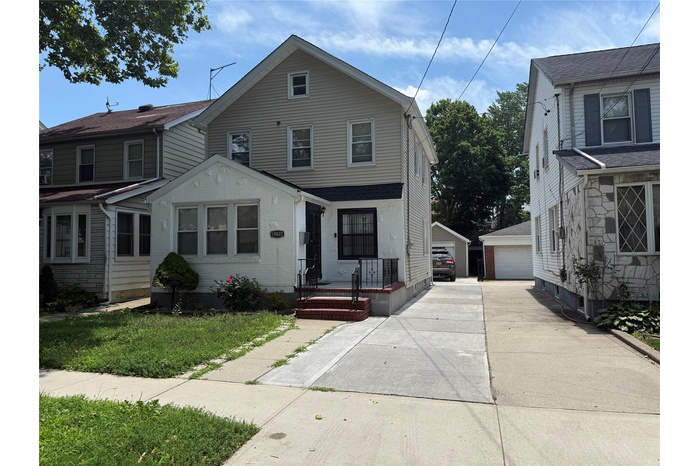 View of front facade with an outdoor structure and a detached garage