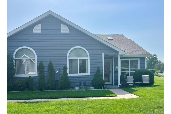 View of front of house featuring a front yard and a shingled roof