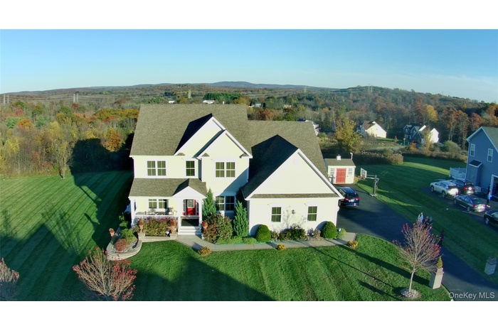 Aerial view of property and surrounding area with a heavily wooded area