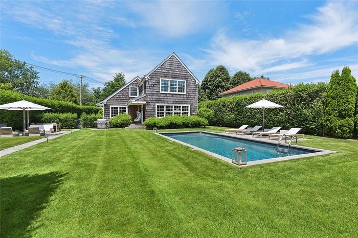 Back of house with an outdoor pool, a yard, and a patio area