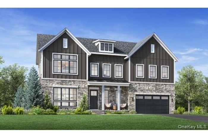 View of front of home with stone siding, board and batten siding, and a front lawn