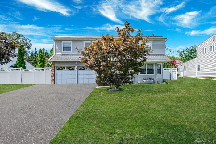 View of front of property with an attached garage, driveway, and roof with shingles
