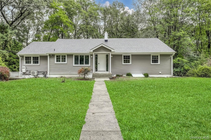 Ranch-style home with roof with shingles, a front yard, entry steps, and a chimney
