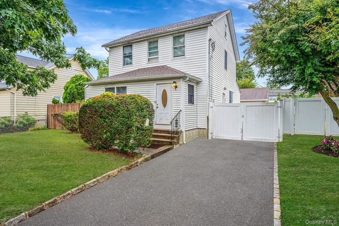 View of front of house with a gate, a shingled roof, asphalt driveway, and entry steps