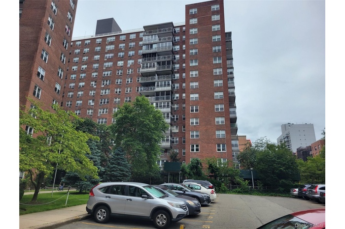 View of apartment building / complex with uncovered parking
