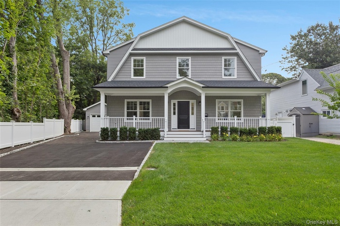 Dutch colonial featuring a gambrel roof, covered porch, roof with shingles, and an outbuilding