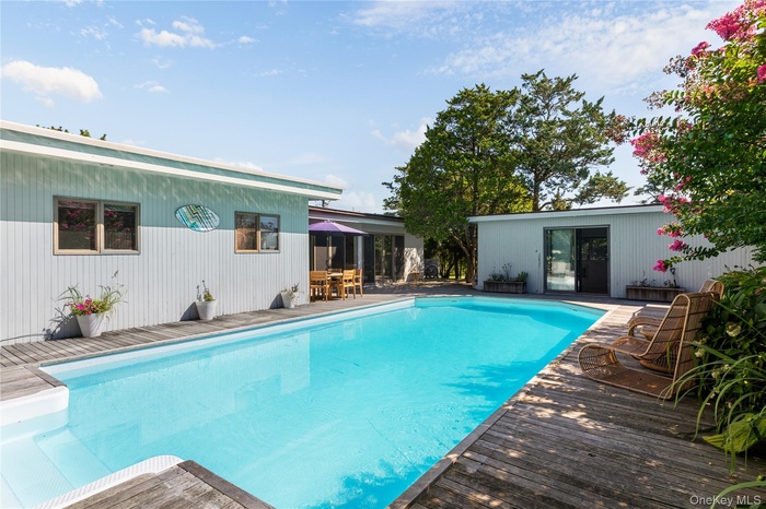 Outdoor pool with a patio area, a deck, and outdoor dining space