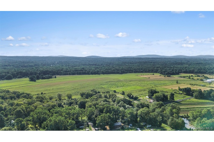 Overview of rural landscape with a heavily wooded area and mountains
