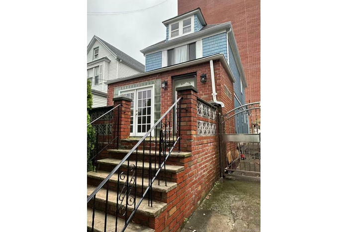 View of exterior entry with brick siding and a gate