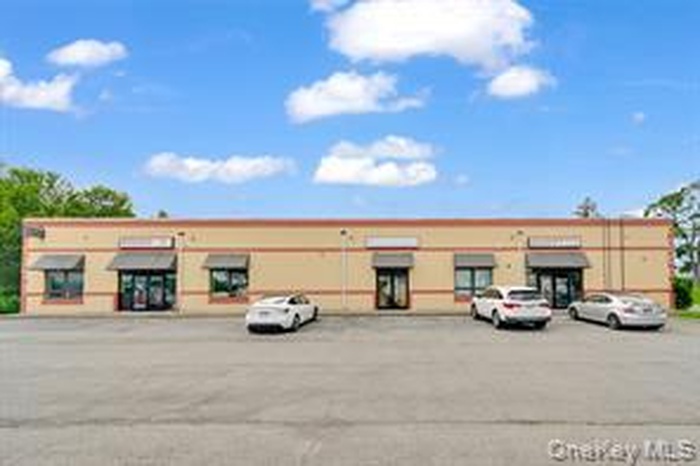 View of commercial location featuring uncovered parking