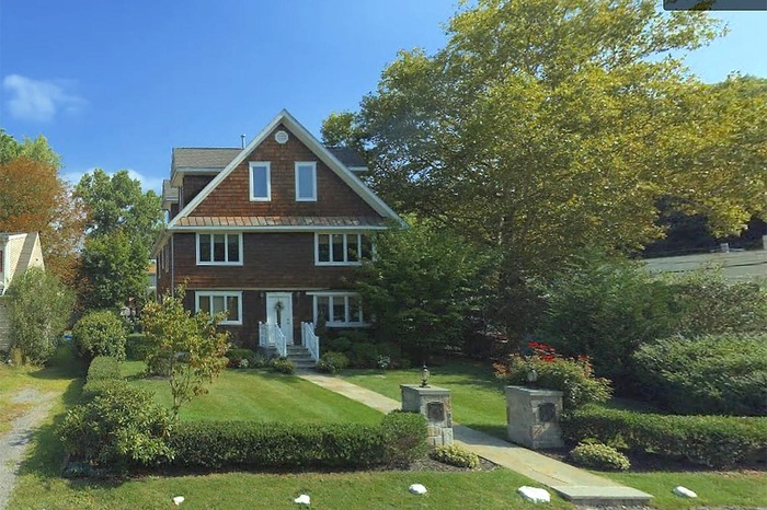 Shingle-style home featuring a front lawn