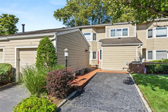 View of front of house with a deck and roof with shingles