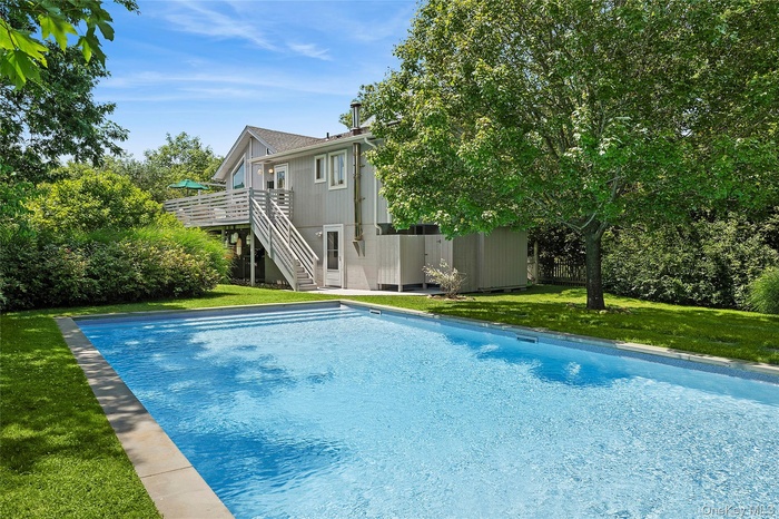 Outdoor pool featuring a yard, stairway, and a patio area
