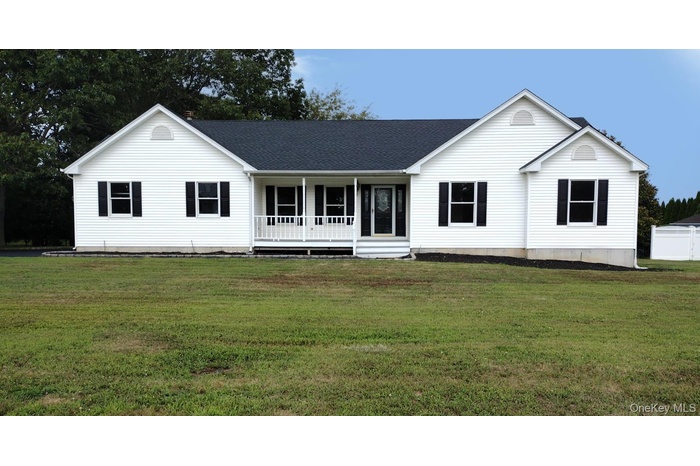 Ranch-style house featuring covered porch, a front yard, and a shingled roof