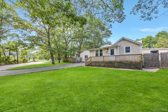View of front facade with driveway and a deck