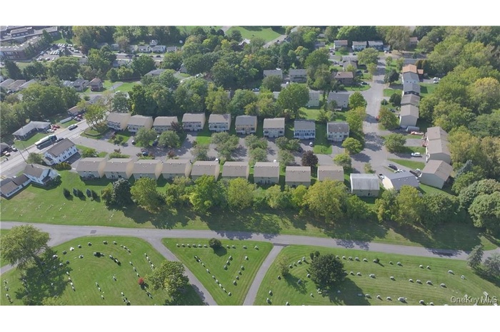 Aerial view of property and surrounding area featuring a tree filled landscape