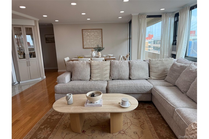 Living room featuring wood finished floors, recessed lighting, and crown molding