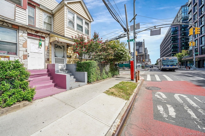 View of asphalt road with sidewalks, curbs, and street lighting