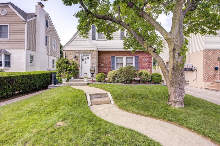 View of front facade with a front lawn and brick siding