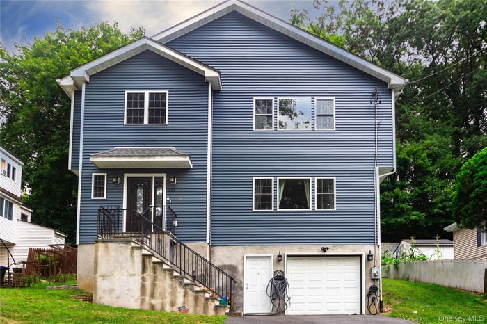 Traditional-style house featuring a garage and asphalt driveway
