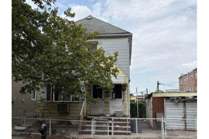 View of front of house featuring a gate, a fenced front yard, and a garage