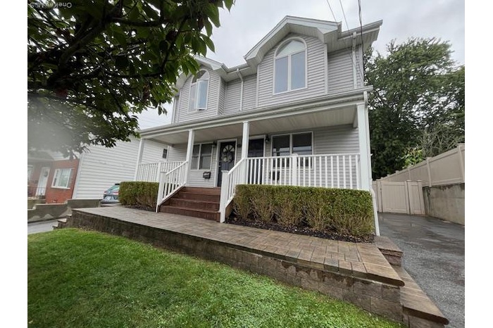 View of front of home with covered porch and a front lawn
